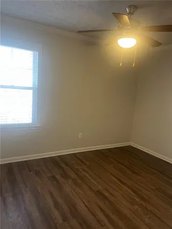 an empty room with wooden floor and windows in a room