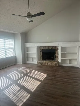 a view of empty room with a fireplace and window