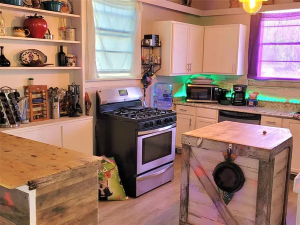 a kitchen with stainless steel appliances granite countertop a stove a sink and a microwave