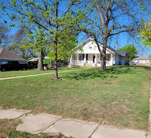 a tree in front of a white house