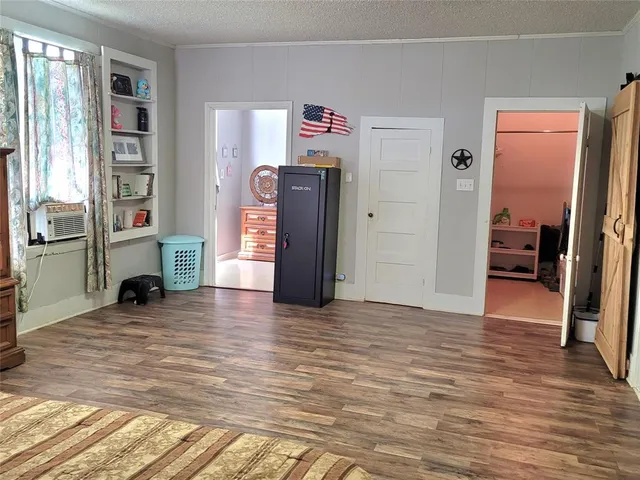 a view of a livingroom with wooden floor and a bookshelf