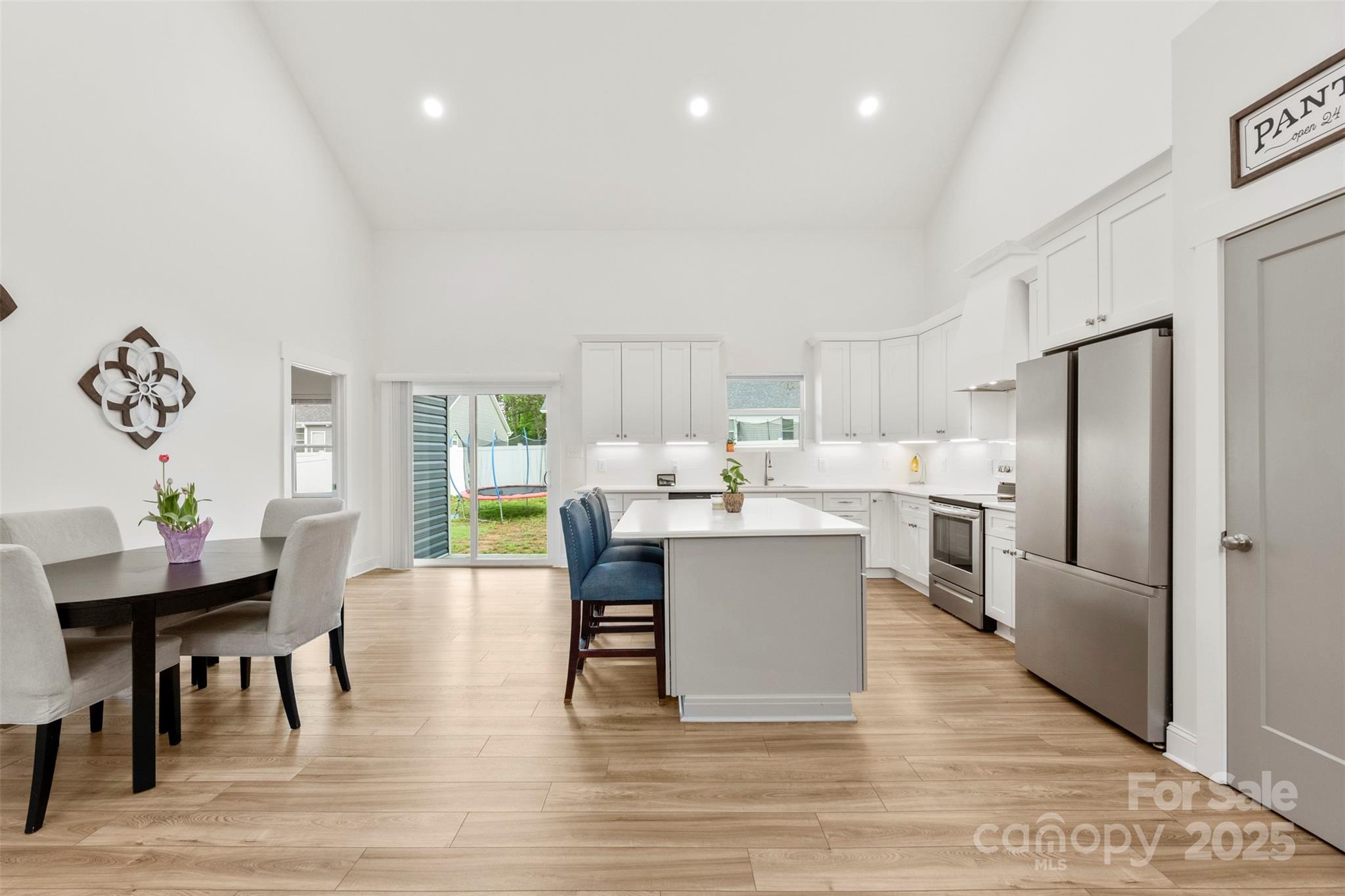 7683 Sarah Drive Denver, NC 28037 - Photo 13 of 25 a kitchen with stainless steel appliances kitchen island granite countertop a table chairs and a refrigerator
