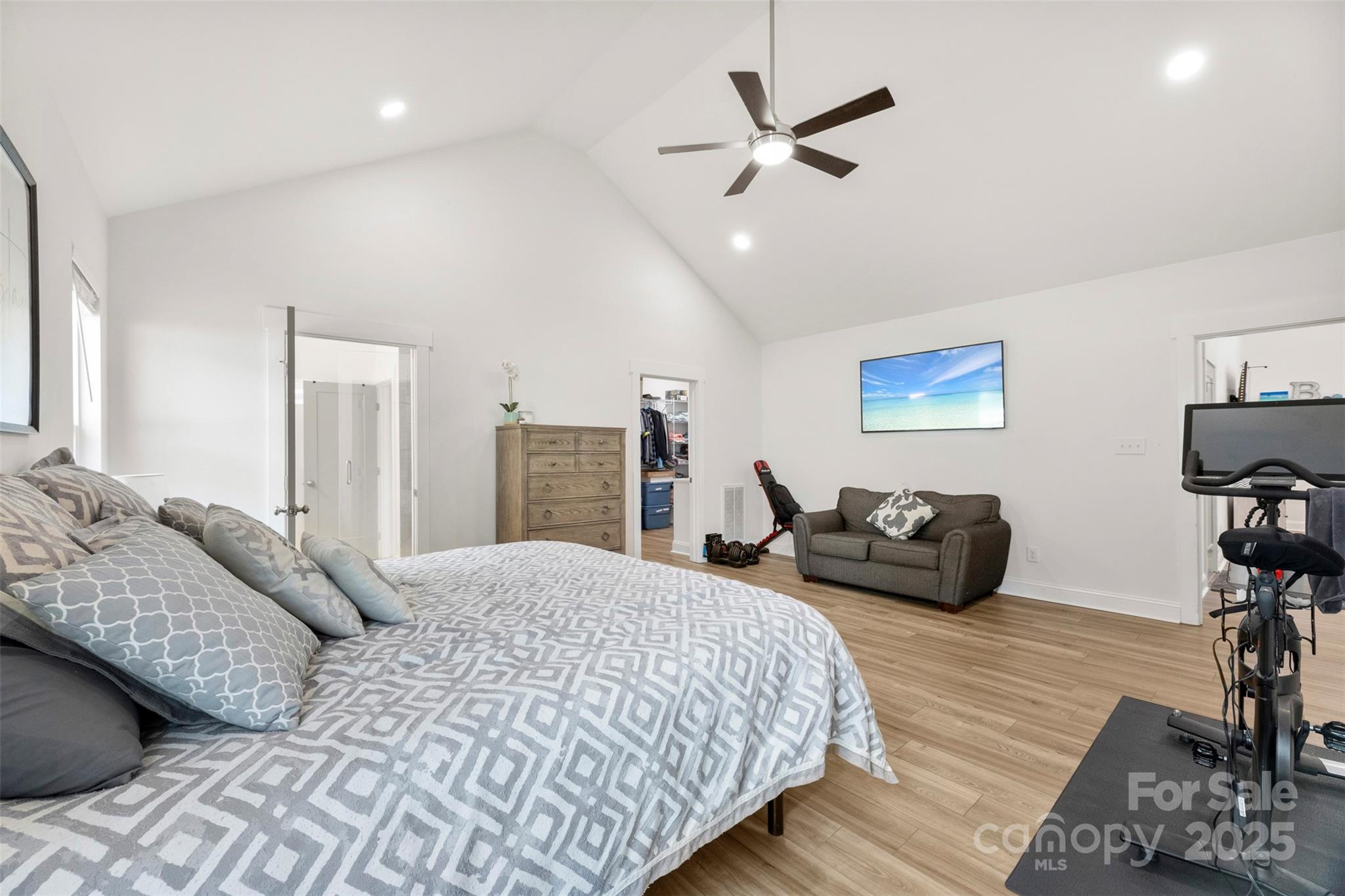 7683 Sarah Drive Denver, NC 28037 - Photo 19 of 25 a spacious bedroom with a bed a couch and a flat screen tv