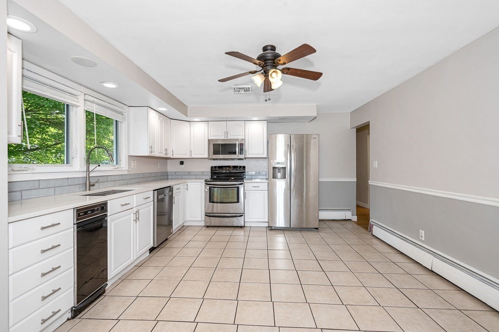 174 Frost Road Tyngsborough, MA 01879 - Photo 3 of 17 a kitchen with a stove a sink and a refrigerator