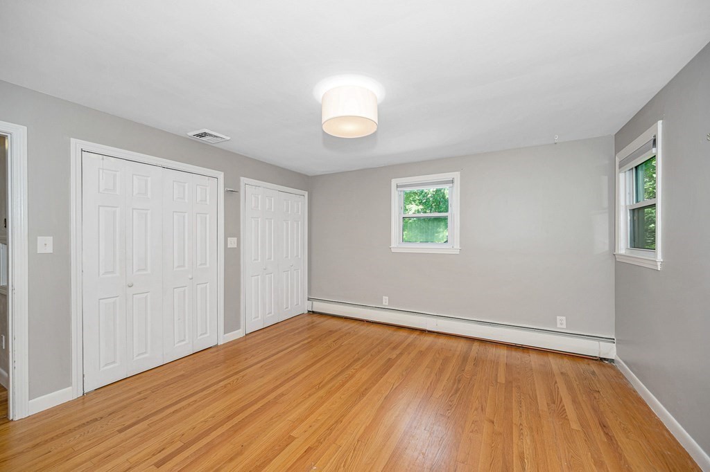 174 Frost Road Tyngsborough, MA 01879 - Photo 5 of 17 an empty room with wooden floor and windows