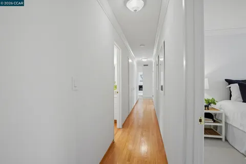 a view of a hallway with wooden floor and furniture