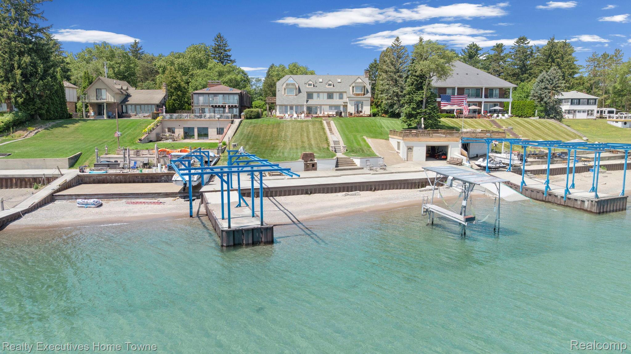 8308 Lakeshore Road Fort Gratiot, MI 48059 - Photo 17 of 79 Waterfront property featuring a private beach, multiple docks, a boathouse, a boat lift, and a landscaped lawn