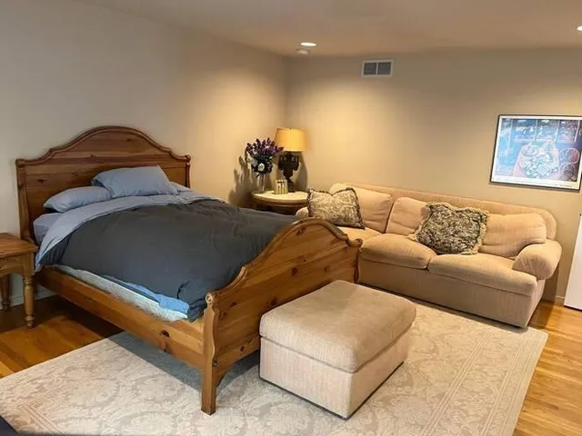 a spacious bedroom with a bed and a flat screen tv
