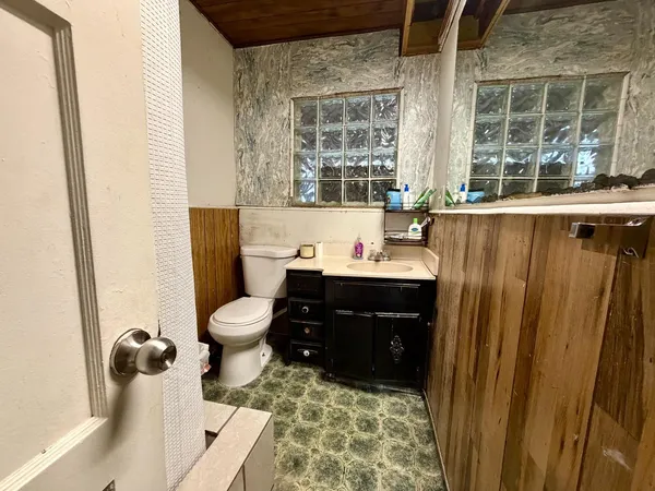 a bathroom with a sink toilet and window