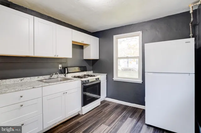 a kitchen with a sink cabinets and wooden floor