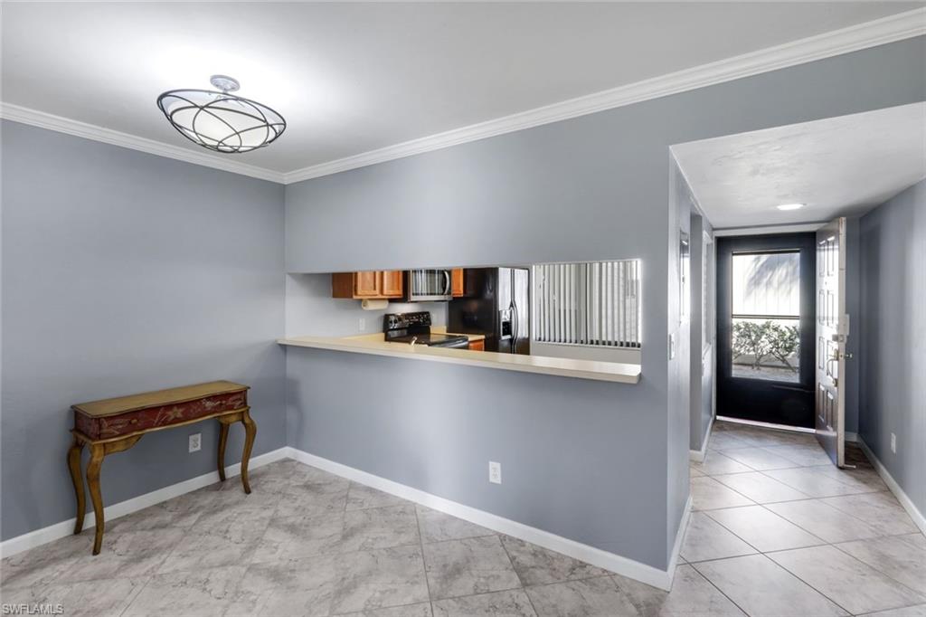 5857 Rattlesnake Hammock Road, Unit 101 Naples, FL 34113 - Photo 10 of 19 Dining area with light gray walls and crown molding