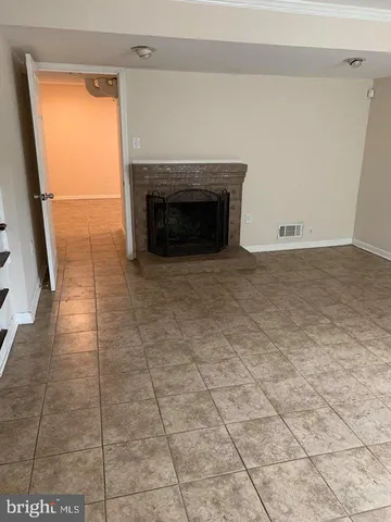 a view of empty room with a fireplace and a window