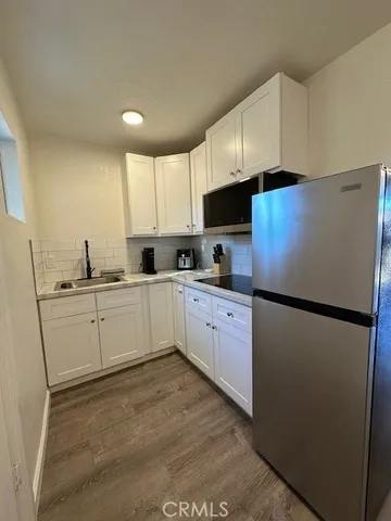 a kitchen with refrigerator a sink and white cabinets