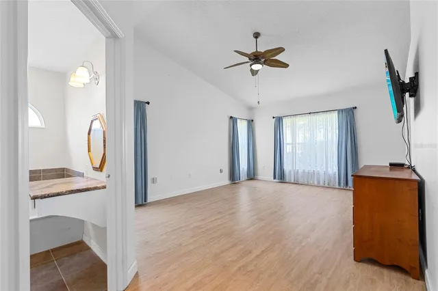 a view of kitchen with white cabinets and a window