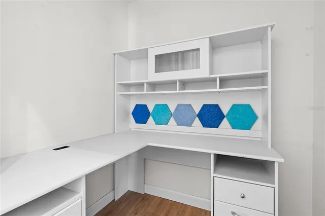 a view of empty room with wooden floor and ceiling fan