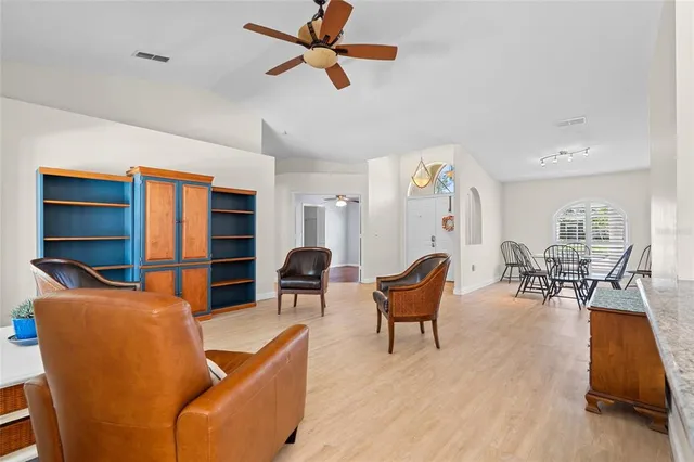 a living room with furniture a ceiling fan and a rug