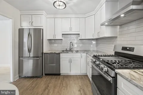 a kitchen with white cabinets and appliances