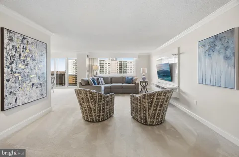 a living room with furniture a flat screen tv and a window