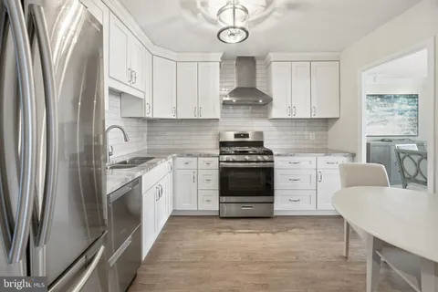 a kitchen with a refrigerator stove and white cabinets