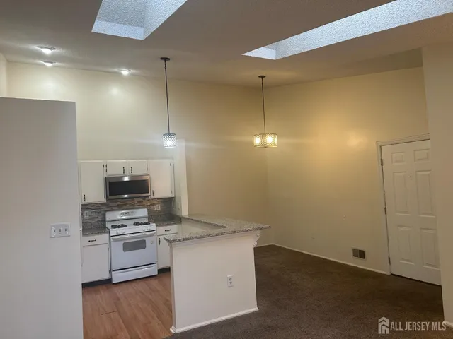 a kitchen with a refrigerator and a stove top oven