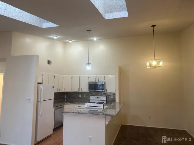 a kitchen with stainless steel appliances a refrigerator and a stove top oven