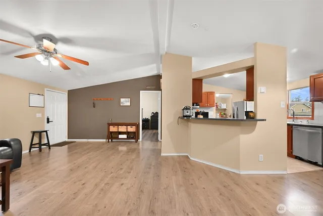 a view of a living room and kitchen with a wooden floor