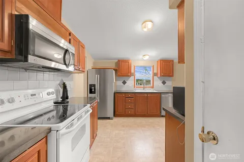 a kitchen with a sink a refrigerator and cabinets
