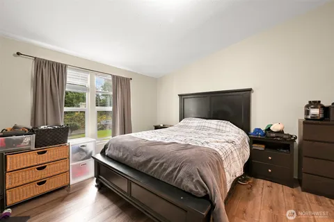 a bedroom with a bed and wooden floor
