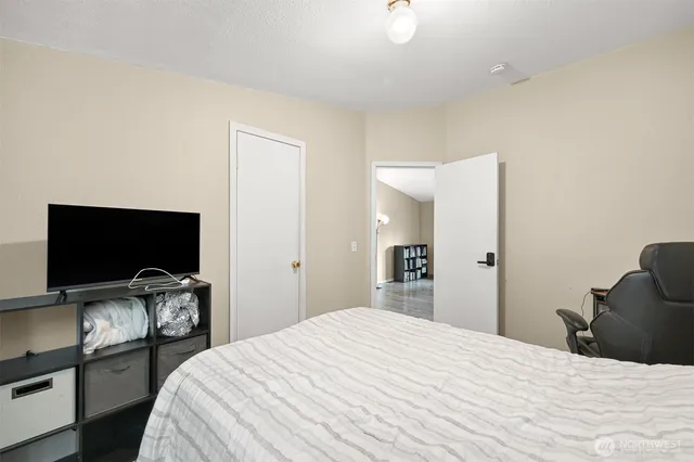 a bedroom with a bed and a flat screen tv