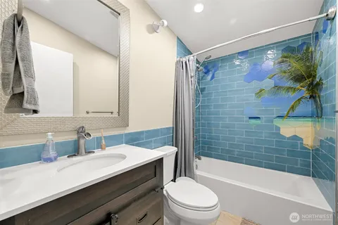 a bathroom with a sink a toilet a mirror a bathtub and shower