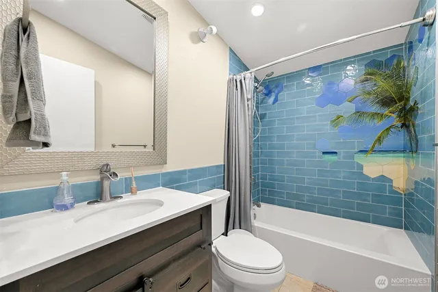 a bathroom with a sink a toilet a mirror a bathtub and shower