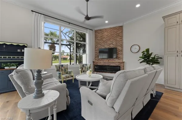 a living room with furniture potted plant and a large window
