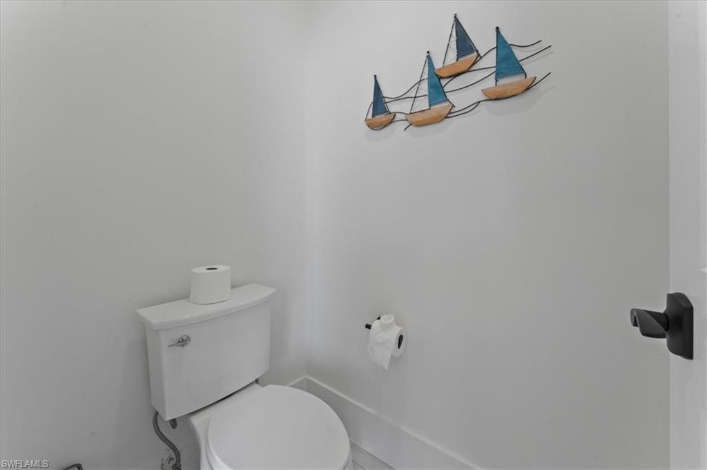 8541 Peppertree Way Naples, FL 34114 - Photo 26 of 41 a white toilet sitting next to a bathroom sink