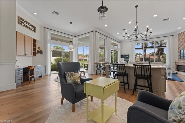 a living room with furniture a fireplace and a chandelier