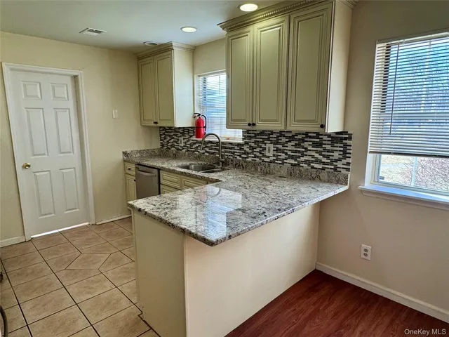 a kitchen with kitchen island granite countertop a sink and a stove