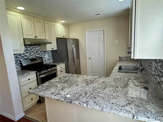 a kitchen with stainless steel appliances granite countertop a sink stove and refrigerator