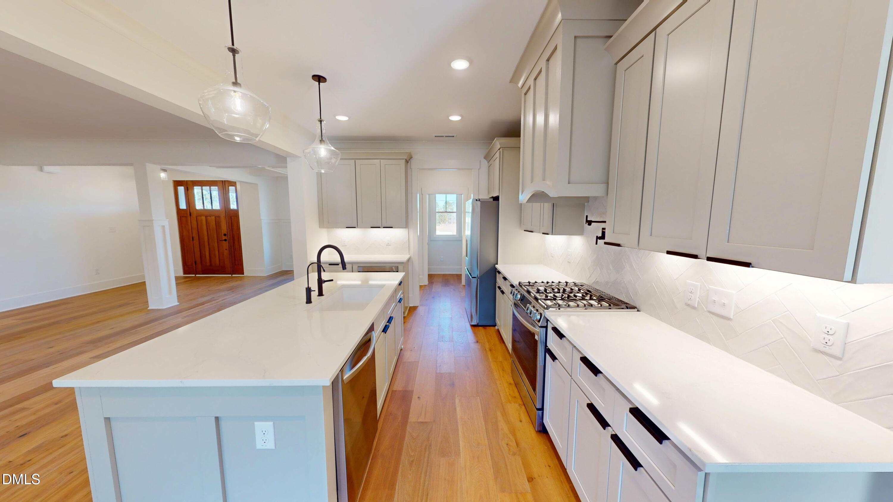 5009 Hopkins Chapel Road Zebulon, NC 27597 - Photo 16 of 28 a large white kitchen with a large window