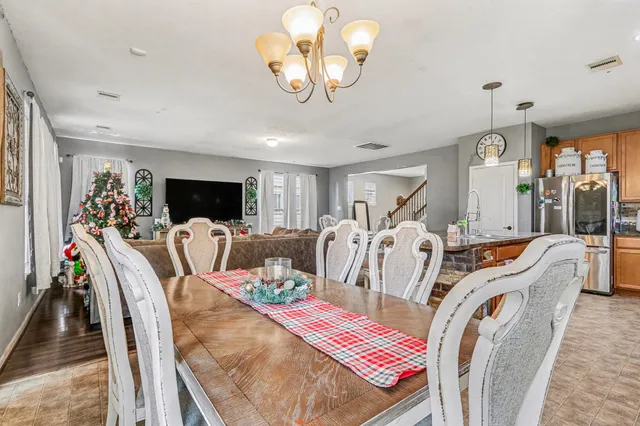 a view of a dining room with furniture a chandelier and wooden floor