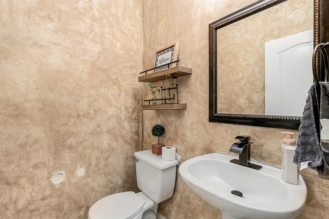 a bathroom with a sink mirror and toilet