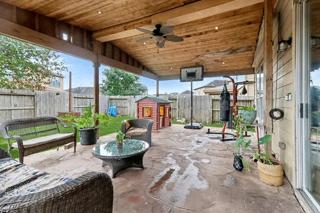 a view of a patio with a table and chairs potted plants