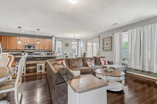 a living room with stainless steel appliances kitchen island granite countertop furniture and a large window