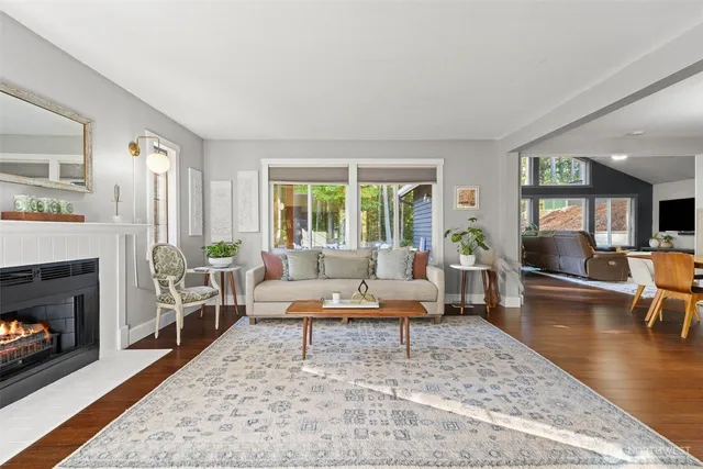 a dining room with wooden floor a chandelier a wooden table and chairs