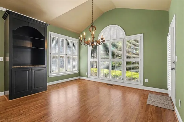 a view of a big room with wooden floor windows and chandelier