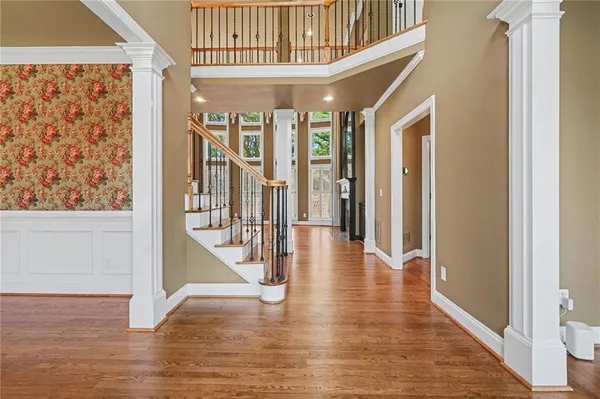 a view of a hallway with wooden floor and staircase