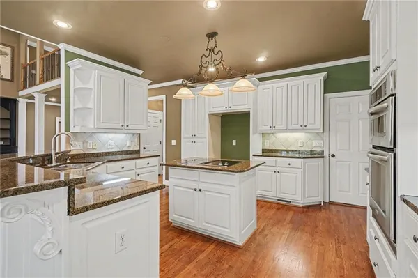 a kitchen with a stove and a wooden floor