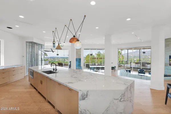 a view of a kitchen with kitchen island a counter top space appliances and cabinets