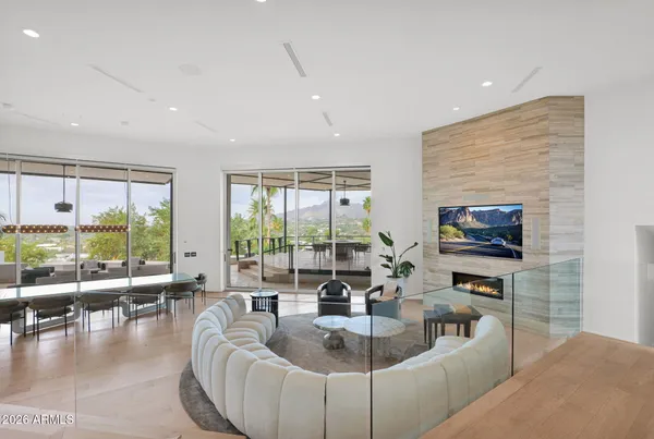 a living room with furniture two large windows and a fireplace