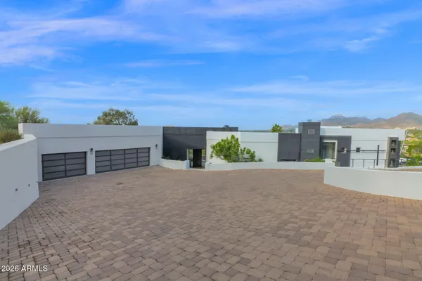 a view of a house with a yard and potted plants