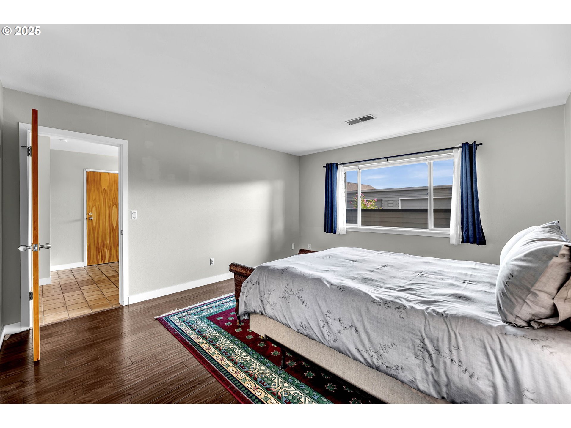 6902 Southeast Riverside Drive, Unit 6 Vancouver, WA 98664 - Photo 13 of 39 a bedroom with a bed and a dresser with wooden floor