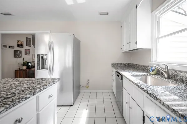 a kitchen with granite countertop a sink stove and refrigerator
